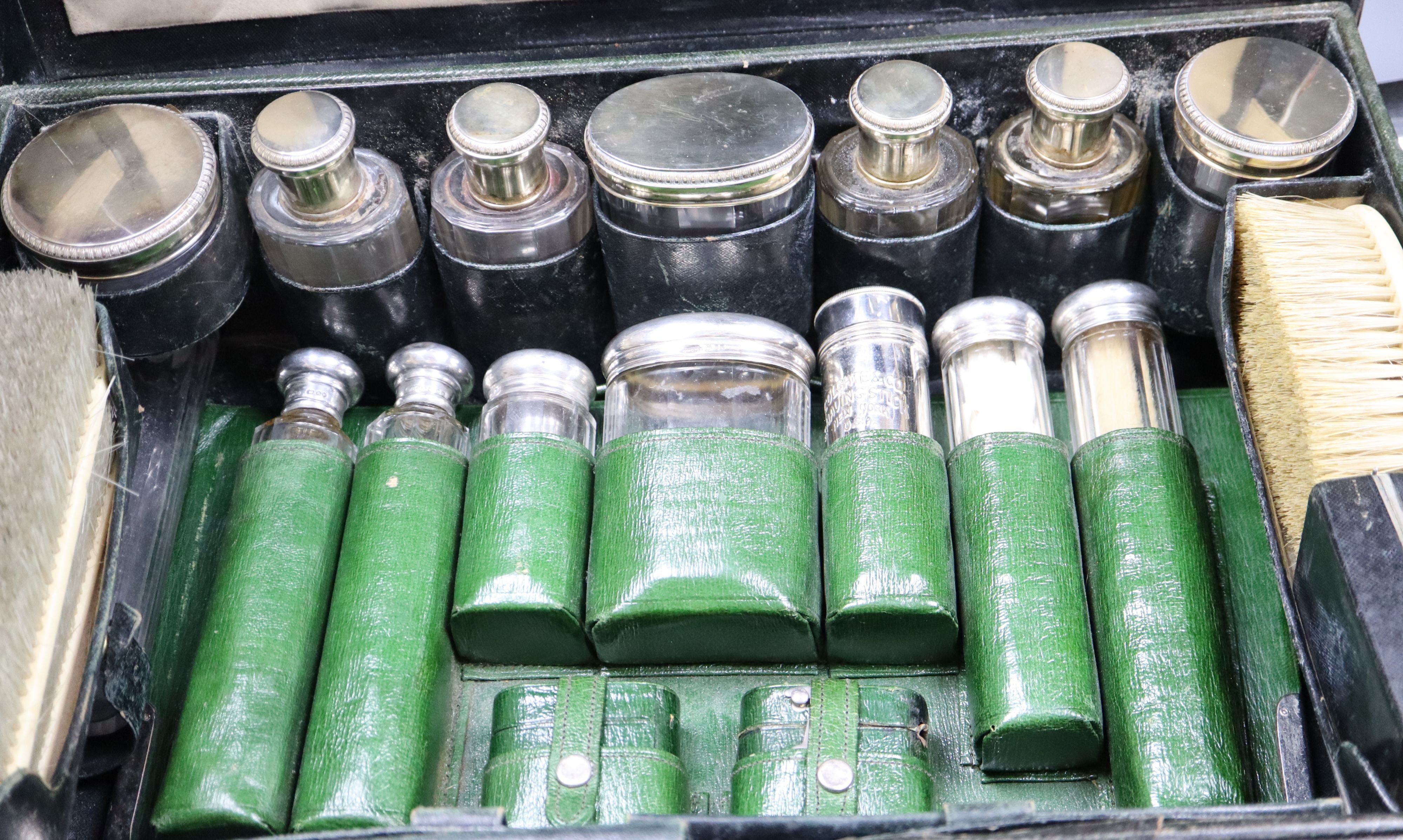 An Edwardian morocco dressing case containing French silver-mounted toilet fitments and valet.